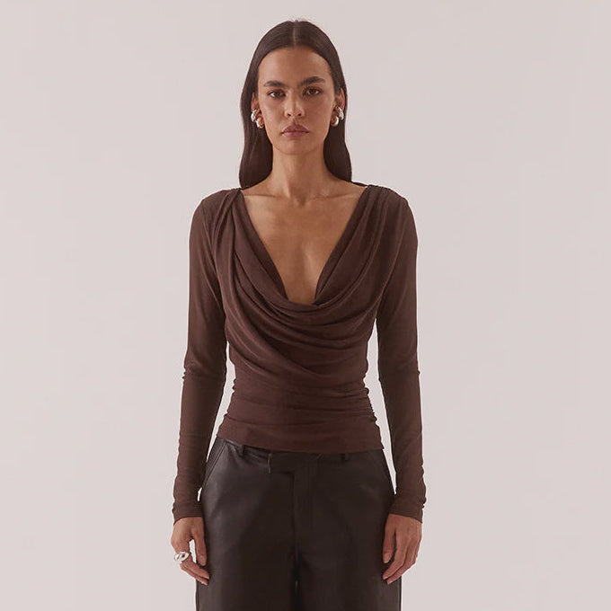 Woman wearing a brown long-sleeve top and wide-leg pants on a white background