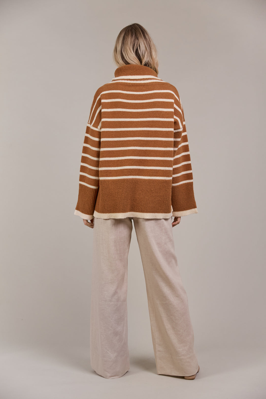 The Katana Roll Neck Knit strikes a balance between timeless and modern, made from sustainably sourced 100% recycled polyester. Available from www.thecollectivenz.com
