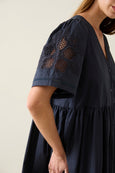 Navy blue isle of mine dress with lace detailing on sleeves against a neutral background