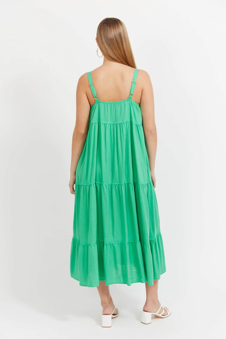 Woman wearing a green Haven dress on a white background