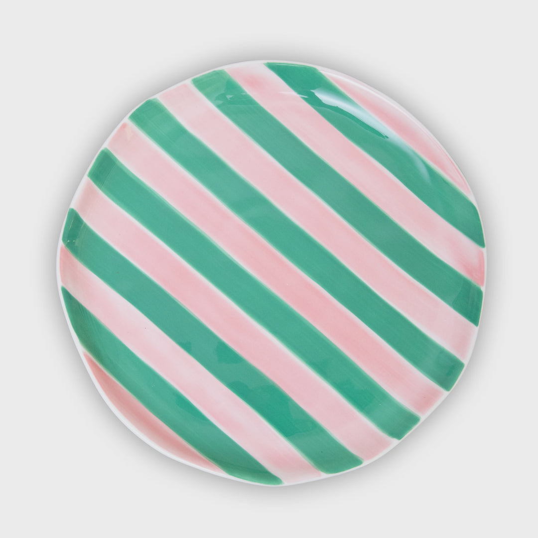 Round plate with green and pink diagonal stripes on a white background