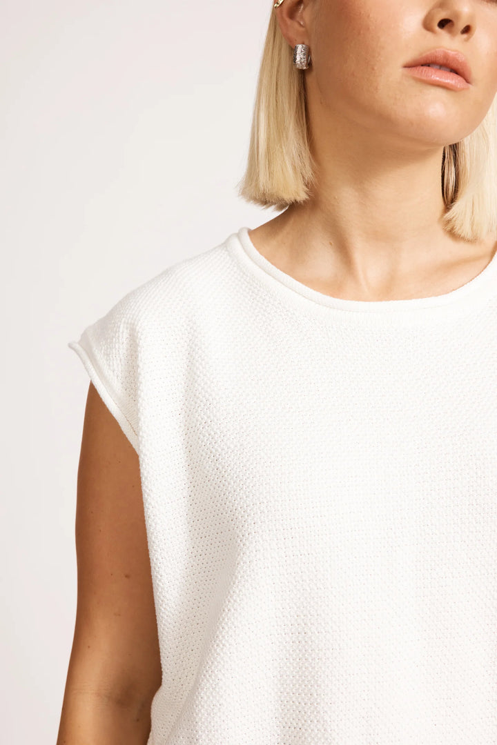 Person wearing a white eb & ive textured top against a plain background