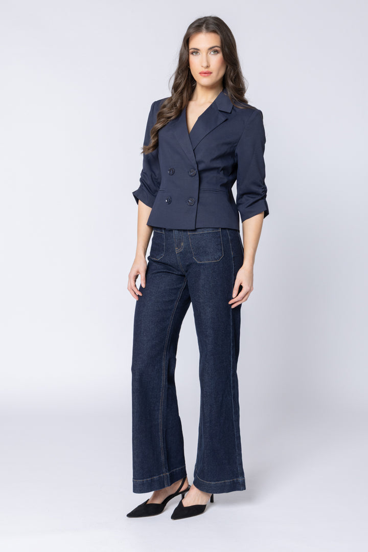 Woman wearing a navy blue jacket with a white background