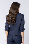 Woman wearing a navy seeking lola blazer and jeans on a white background