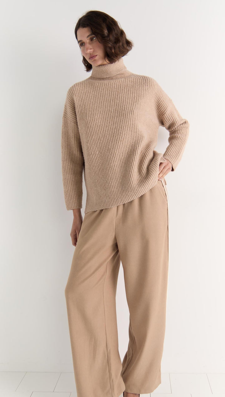 The Cassia Roll Neck Jumper is your answer to elevated everyday comfort. Crafted in a soft, plush knit, this oversized silhouette features a relaxed drop shoulder and cozy roll neck that keeps things snug without sacrificing style. Available from www.thecollectivenz.com