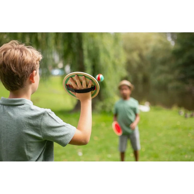 Two children playing with frisbees in a park