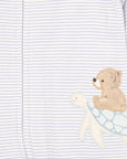 Close-up of a baby outfit with a bear and whale design on a striped background