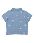 Bebe Blue polo shirt with airplane patterns on a white background