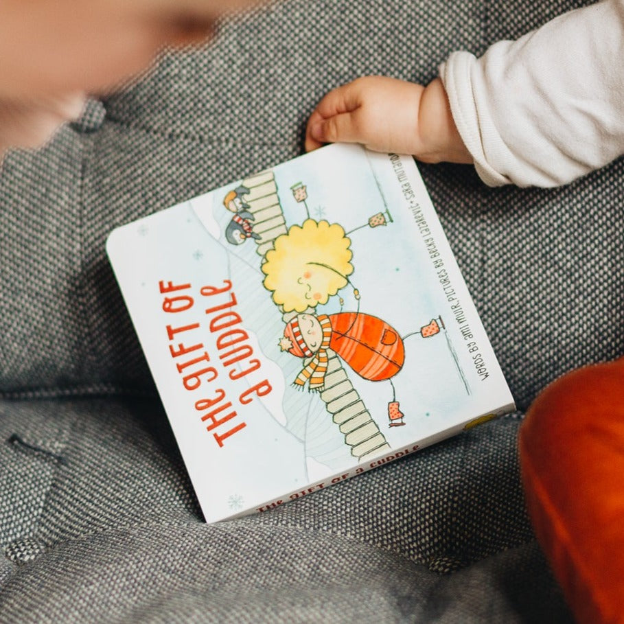 The gift of a cuddle board book is Told by a grown up trying to make the perfect cuddle for their little one, this book is about all of the wonderful things cuddles can do. Available from www.thecollectivenz.com