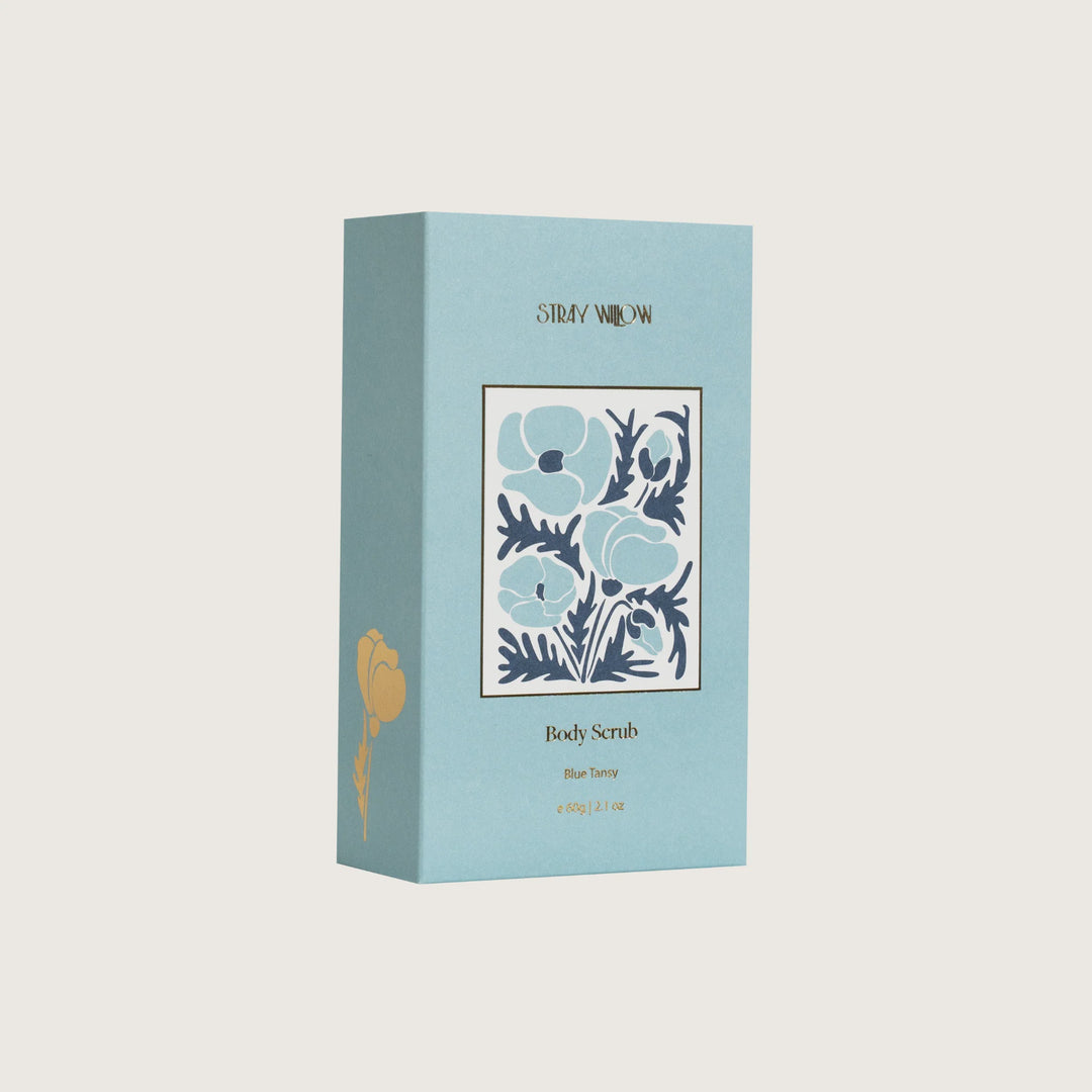 Blue box of body scrub with floral design and 'Sally Weigand' branding on a light gray background