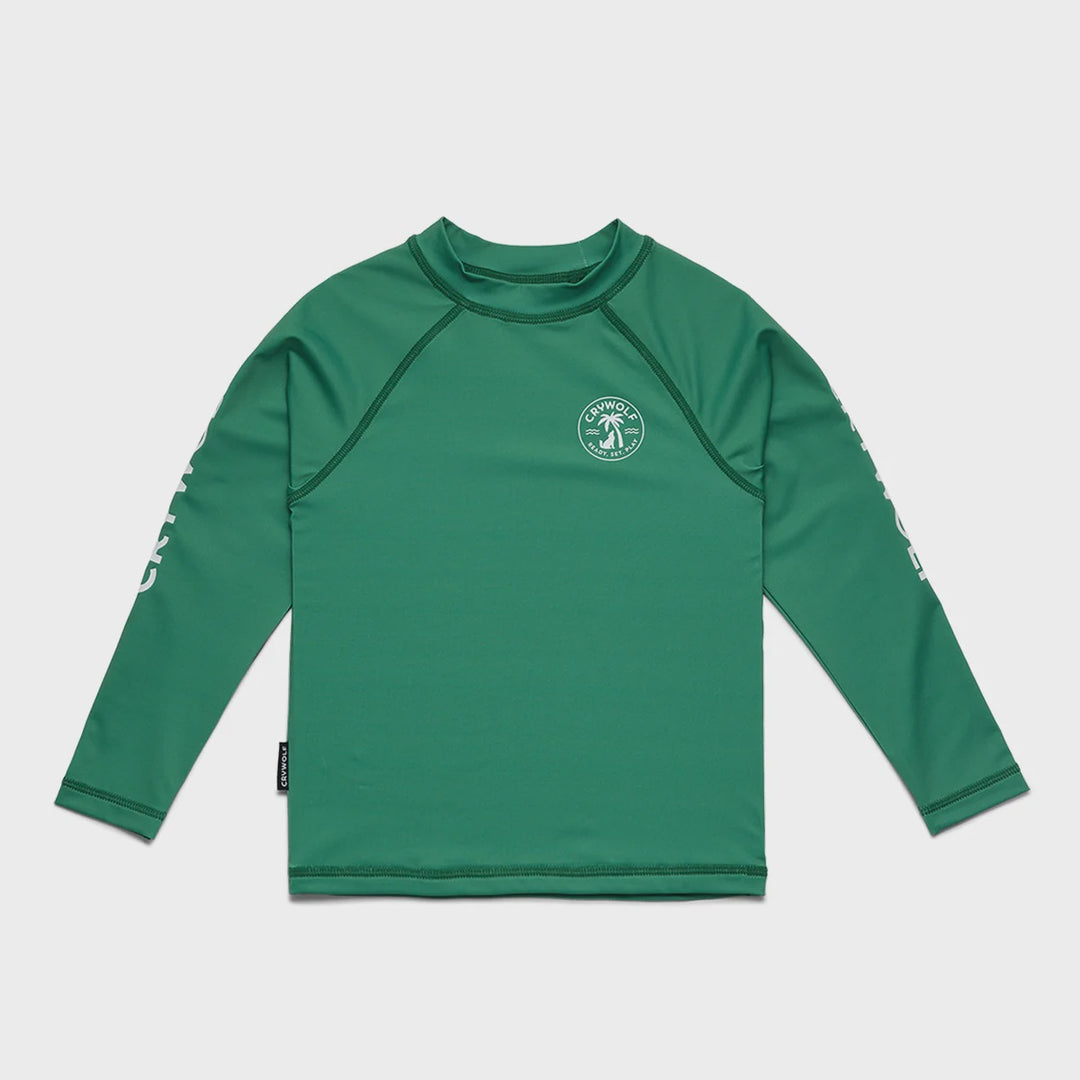 A green long-sleeve rash guard with raglan sleeves, a mock neck, and a circular logo on the left chest, displayed flat against a light gray background.