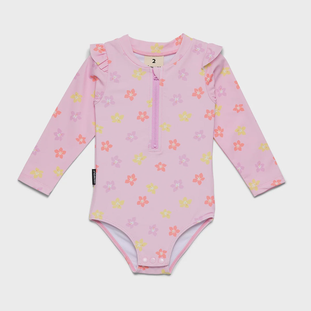 A baby long-sleeve swim bodysuit in light pink with a floral print in yellow, orange, and purple, featuring a half-zip neckline.