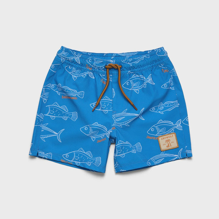 Blue swim trunks with a white fish pattern, featuring a brown drawstring and a small brown brand patch on the lower left leg, shown flat on a light gray background.