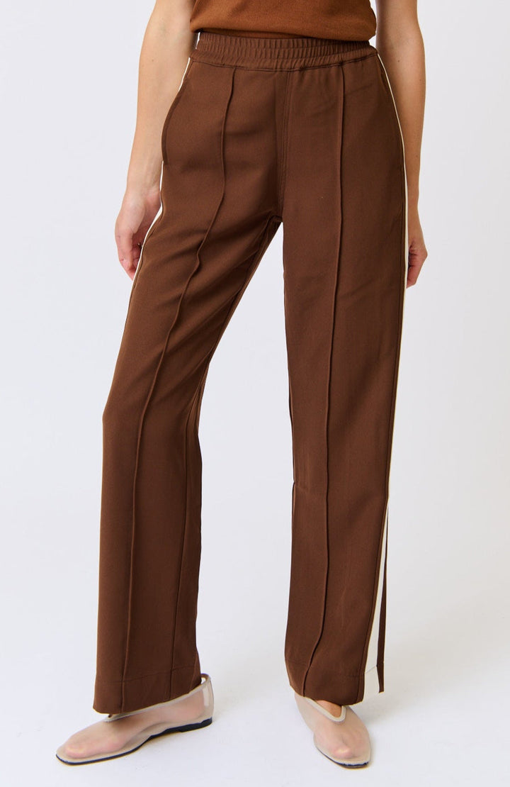Brown pants worn by a person on a white background