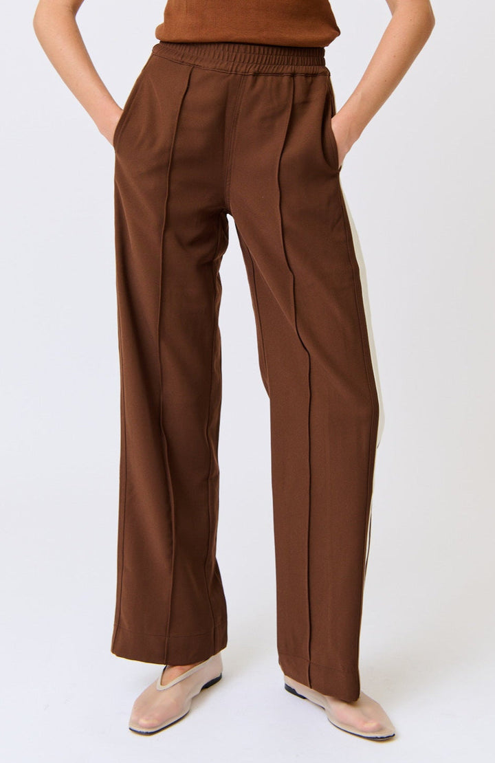 Brown pants worn by a person on a white background