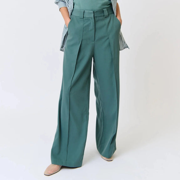 Woman wearing a teal outfit with a white background