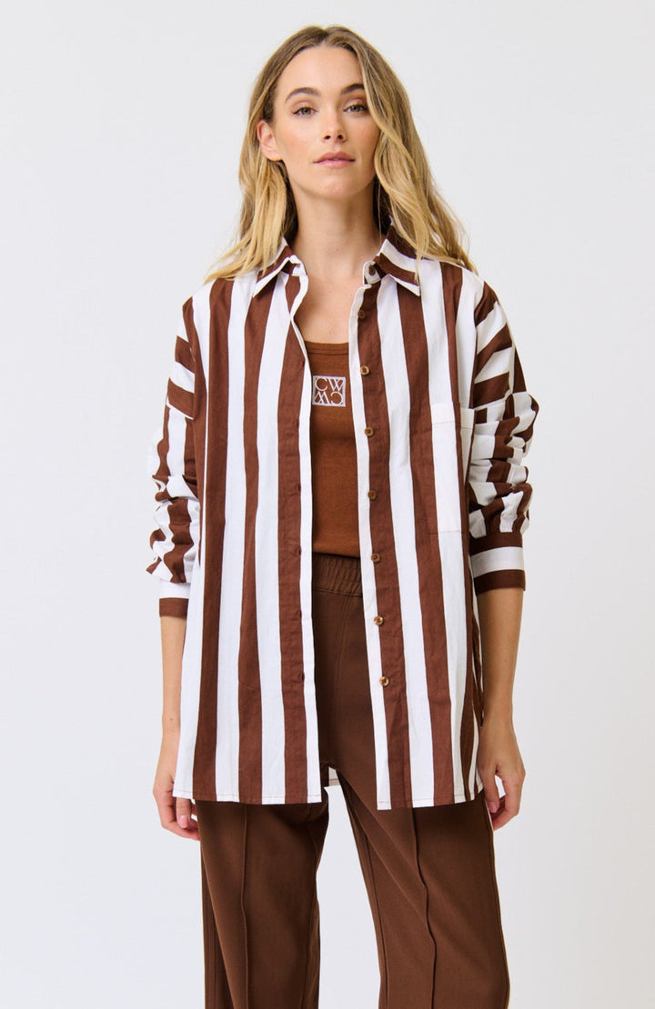 Woman wearing a brown and white striped shirt with a plain background
