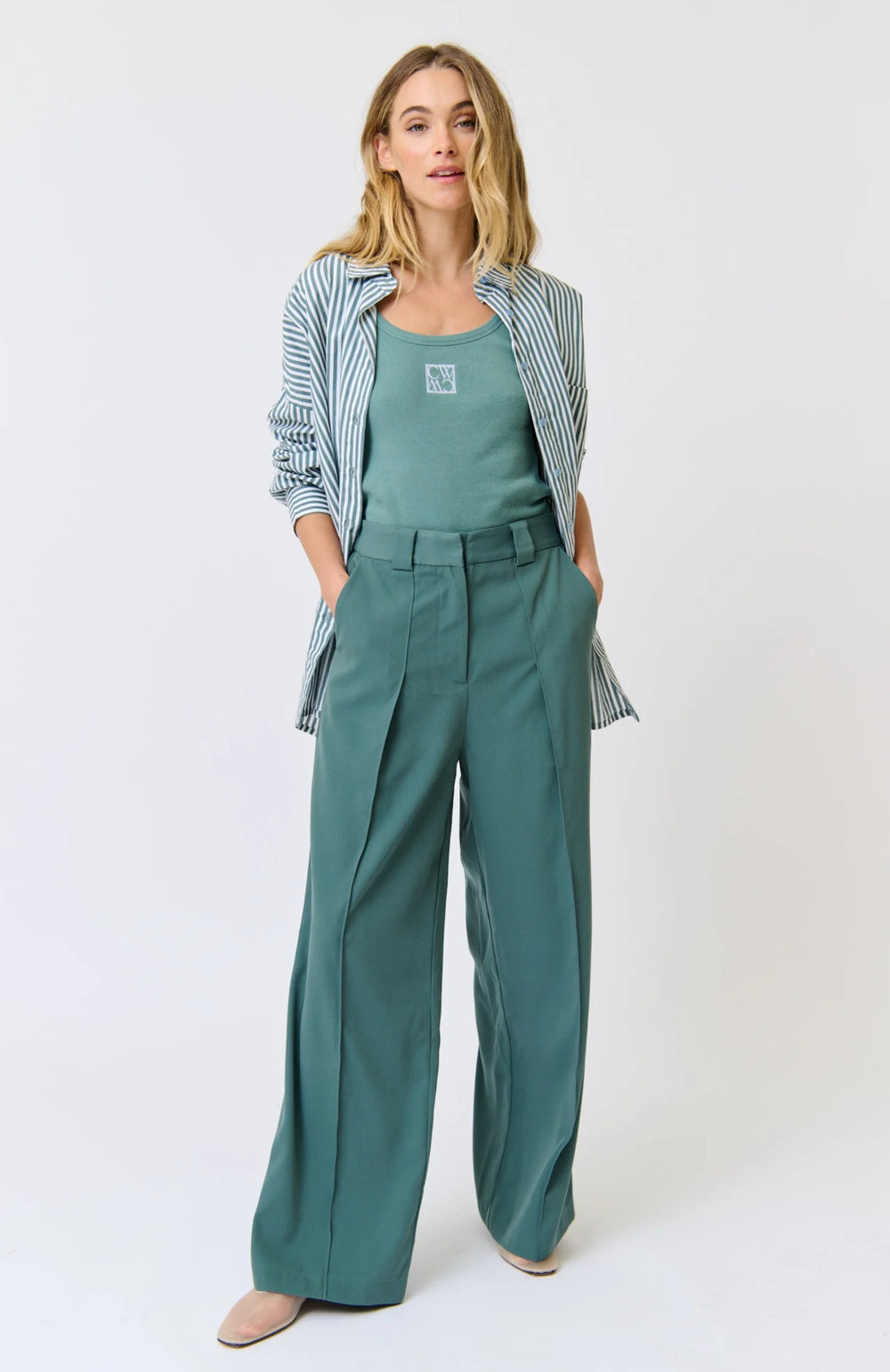 Woman wearing a teal outfit with a white background