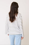 Person wearing a striped cartel & willow river long-sleeve shirt and light blue jeans on a plain background