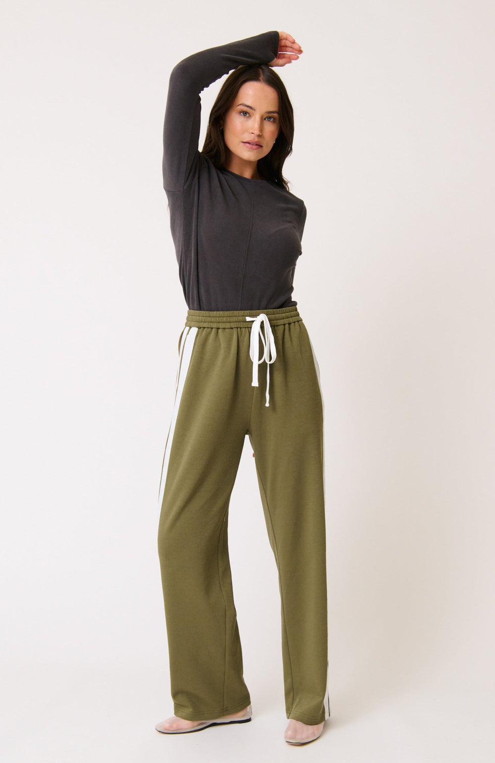 Woman wearing a dark gray long-sleeve top and cartel & willow olive green adline  pants on a white background