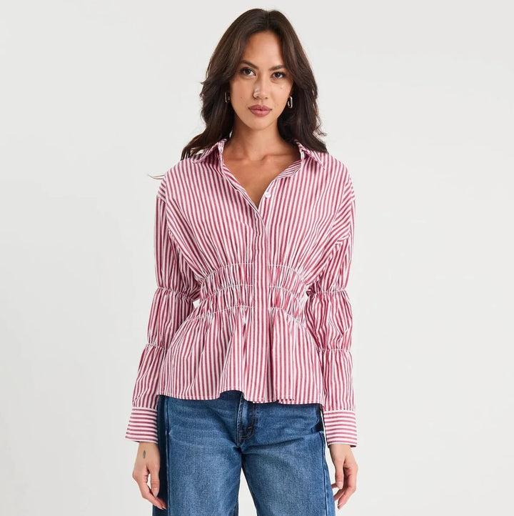 Woman wearing a red and white striped shirt with blue jeans on a white background