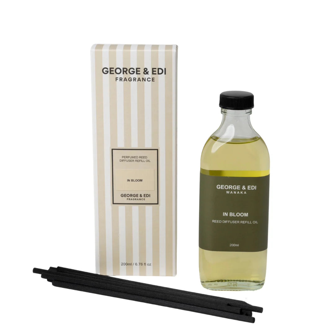 George & Edi fragrance oil bottle with packaging and reeds on a white background