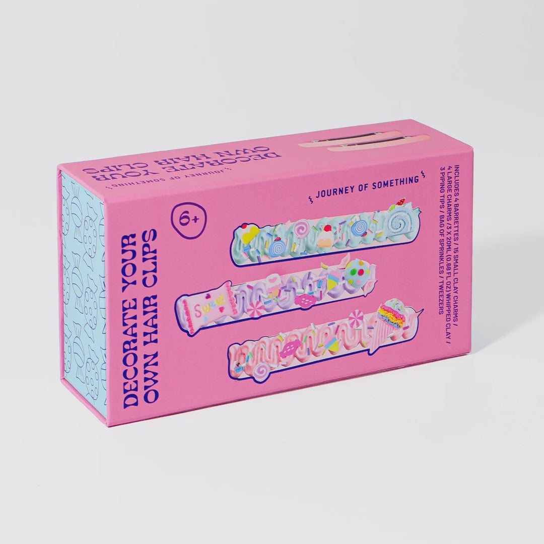 Pink box of decorate your own hair clips on a white background