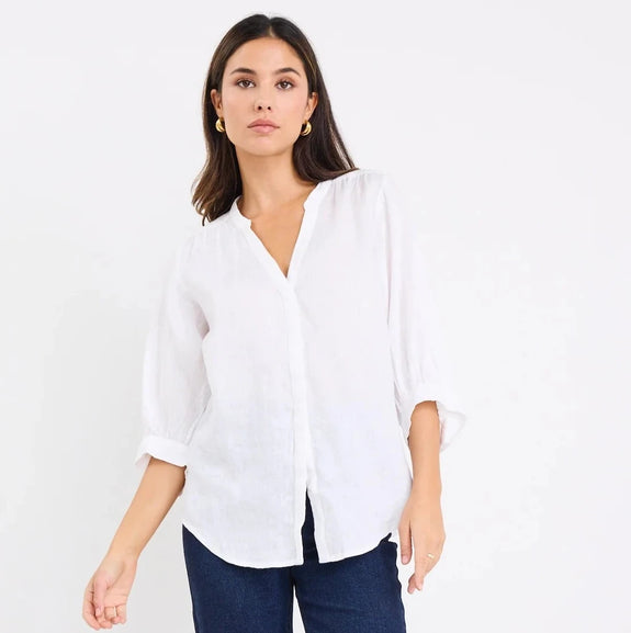 Woman wearing a white blouse and dark blue jeans on a white background