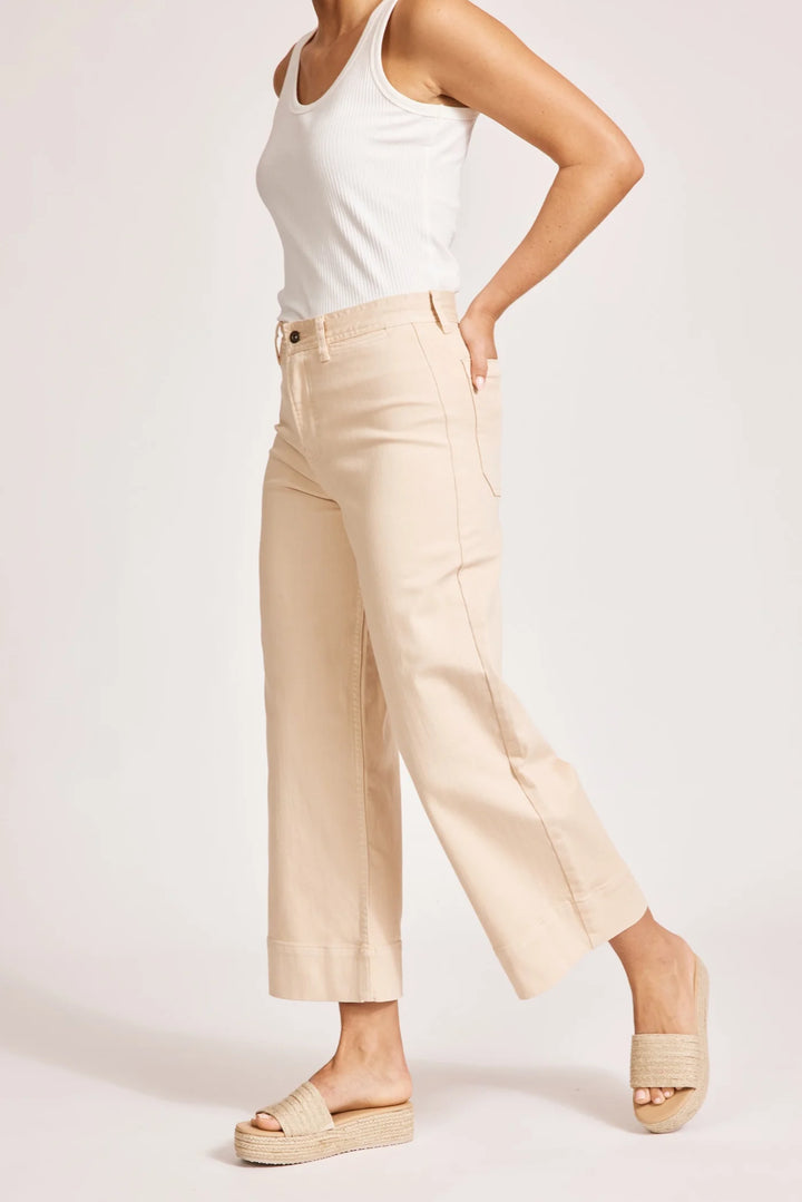 Person wearing Eb & Ive beige pants and a white top on a light pink background
