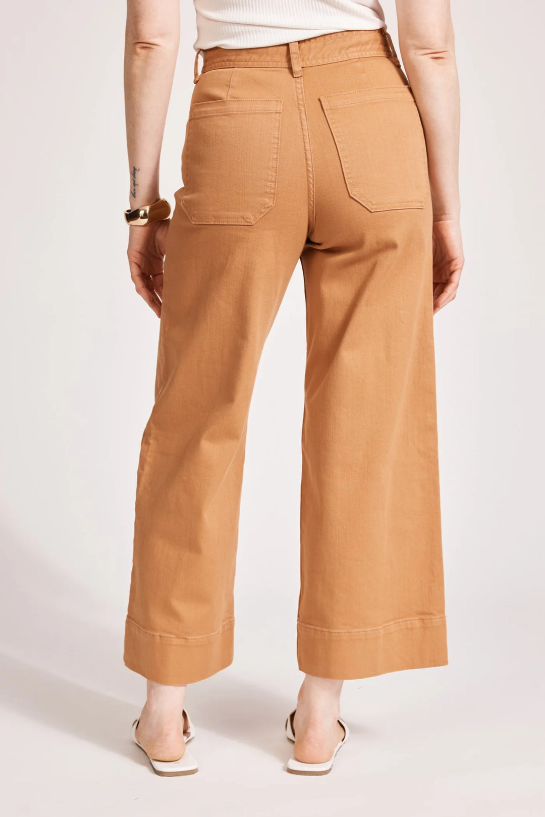 Person wearing eb & ive tan pants on a white background