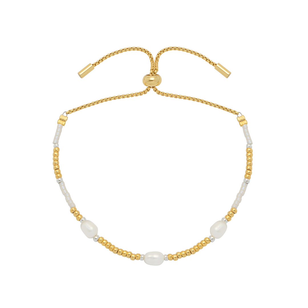 Gold and white beaded bracelet on a white background