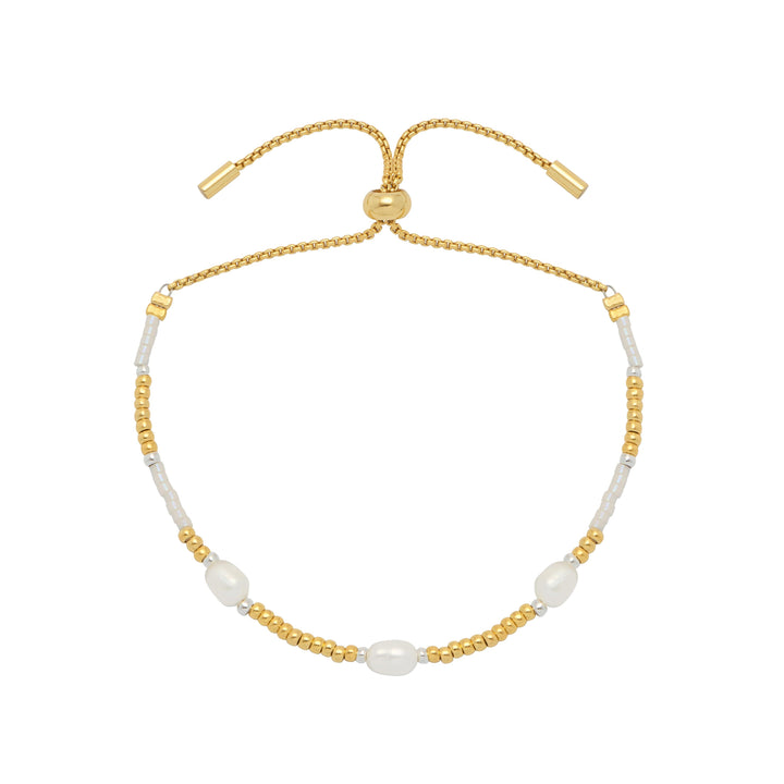 Gold and white beaded bracelet on a white background