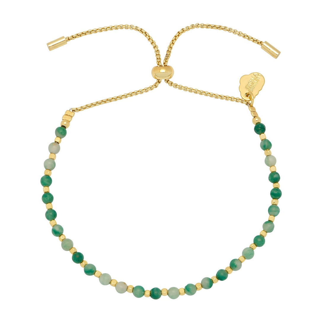 Gold bracelet with green beads on a white background