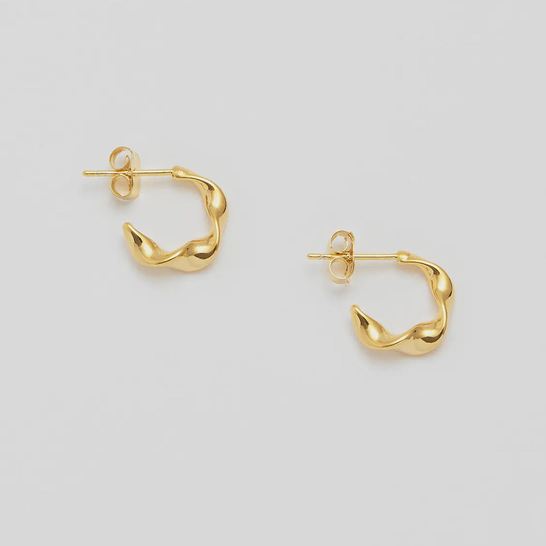 Gold hoop earrings on a light gray background