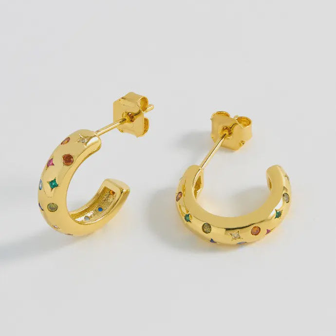 Gold hoop earrings with embedded stones on a light gray background