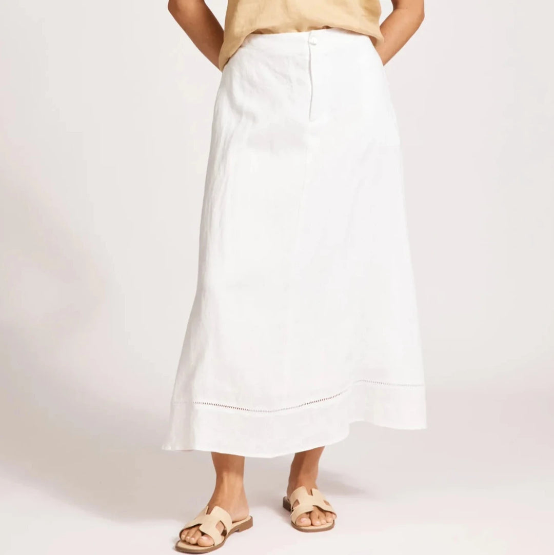Woman wearing a beige top and Eb & Ive white skirt on a plain background