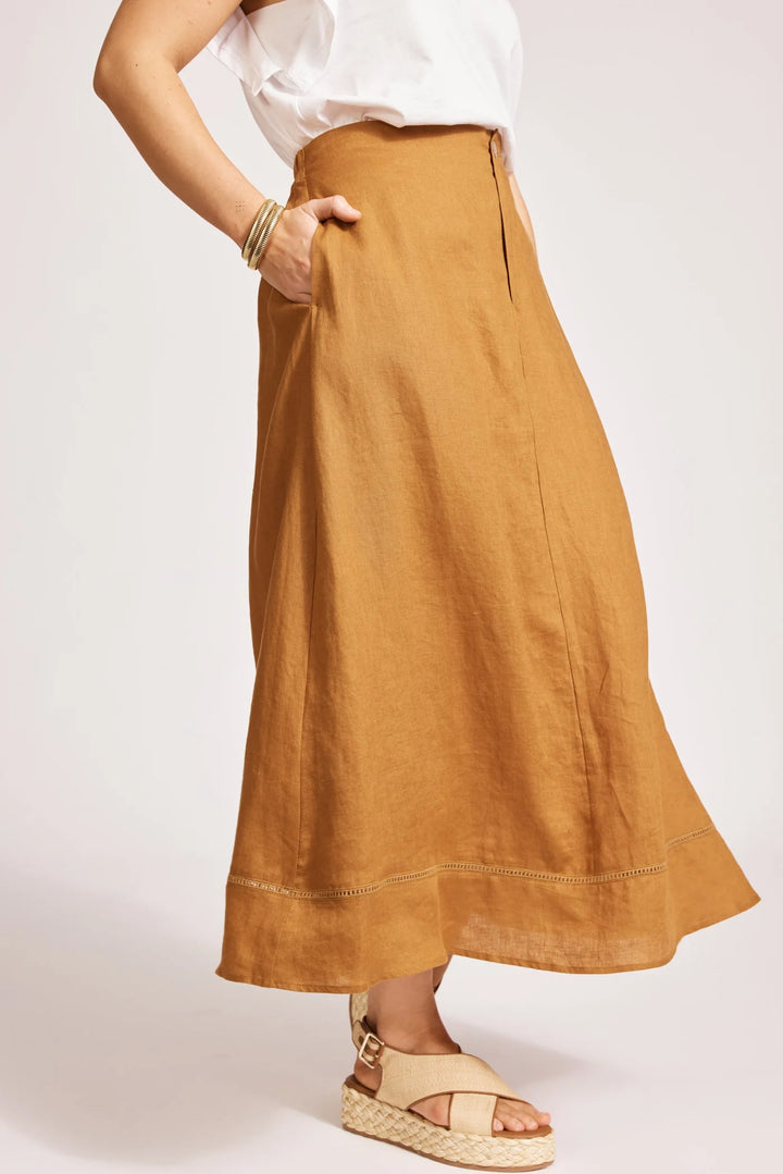 Person wearing a Eb & Ive long mustard yellow skirt on a plain background