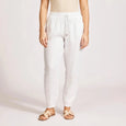 Woman wearing a beige tank top and Eb & Ive white pants on a plain background