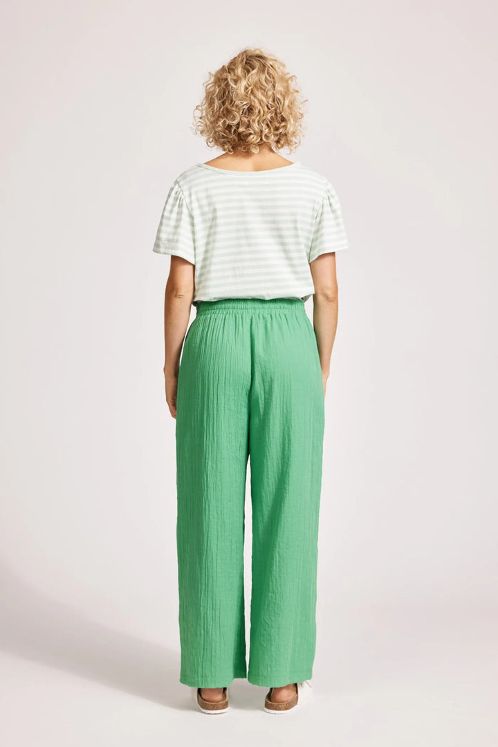 Person wearing a striped shirt and green Eb & Ive pants on a white background
