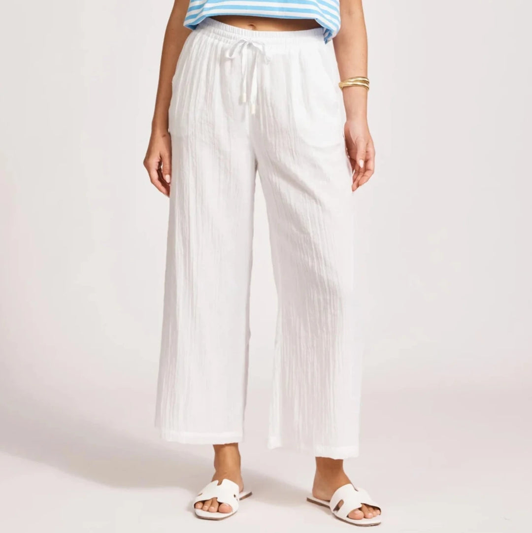 Person wearing a blue and white striped shirt and Eb & Ive white pants on a plain background