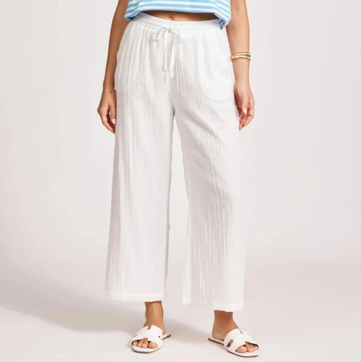 Person wearing a blue and white striped shirt and Eb & Ive white pants on a plain background