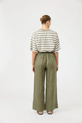 Person wearing a striped shirt and green Eb & Ive wide-leg pants on a white background