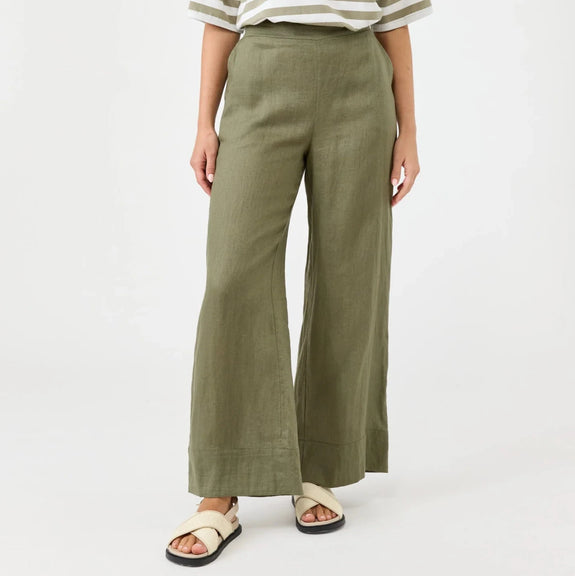 Woman wearing a striped shirt and green Eb & Ive pants on a white background