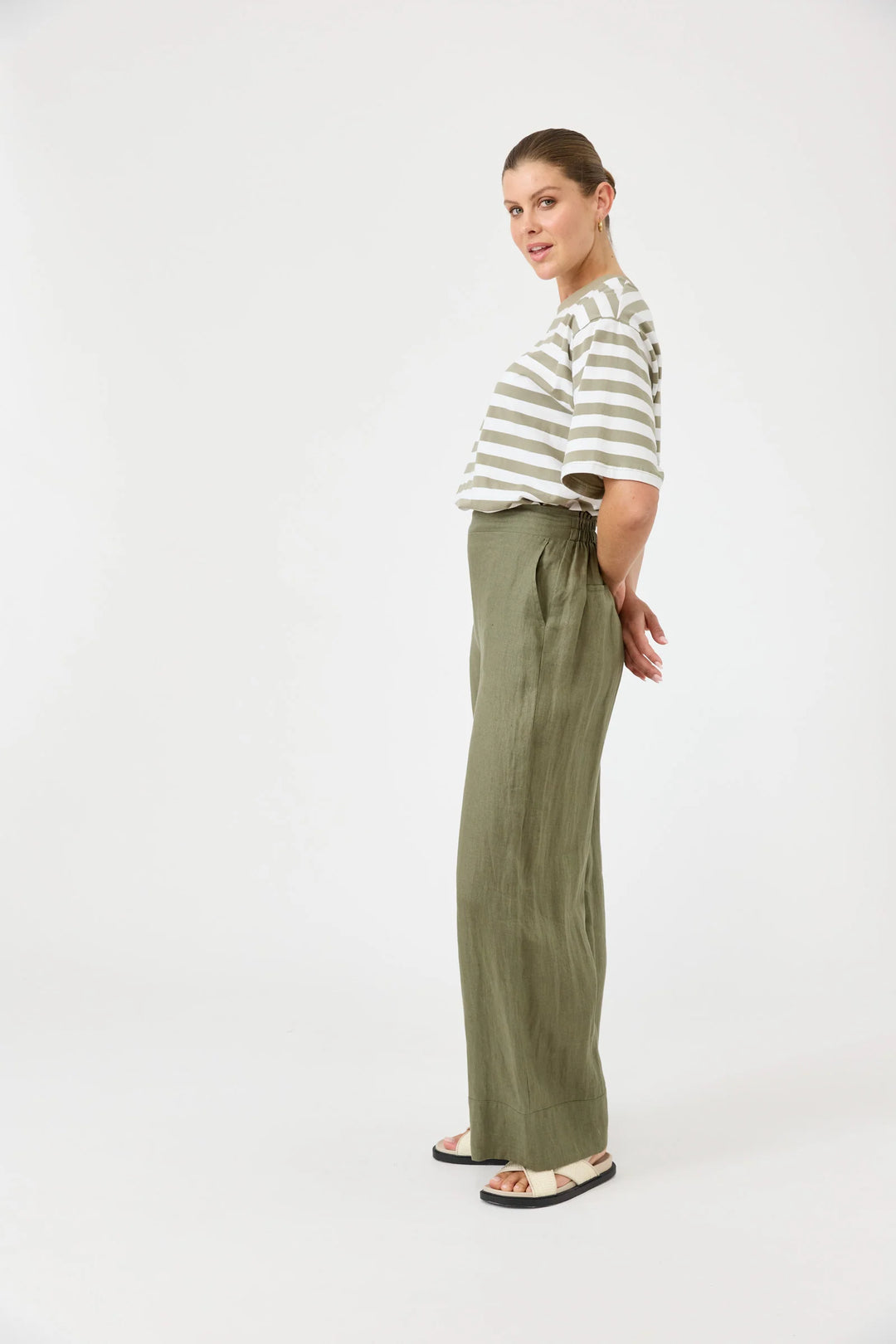 Woman wearing a striped shirt and green Eb & iv pants on a white background