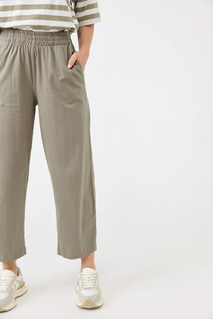 Person wearing beige Eb & Ive pants and a striped shirt on a white background