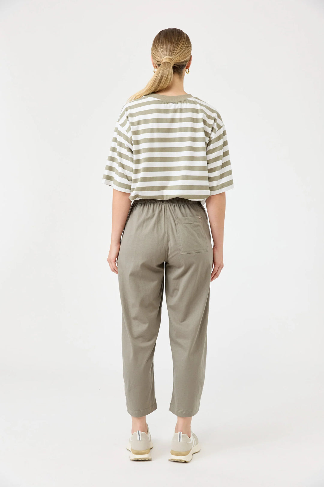 Person wearing a striped shirt and beige Eb & ive pants on a white background
