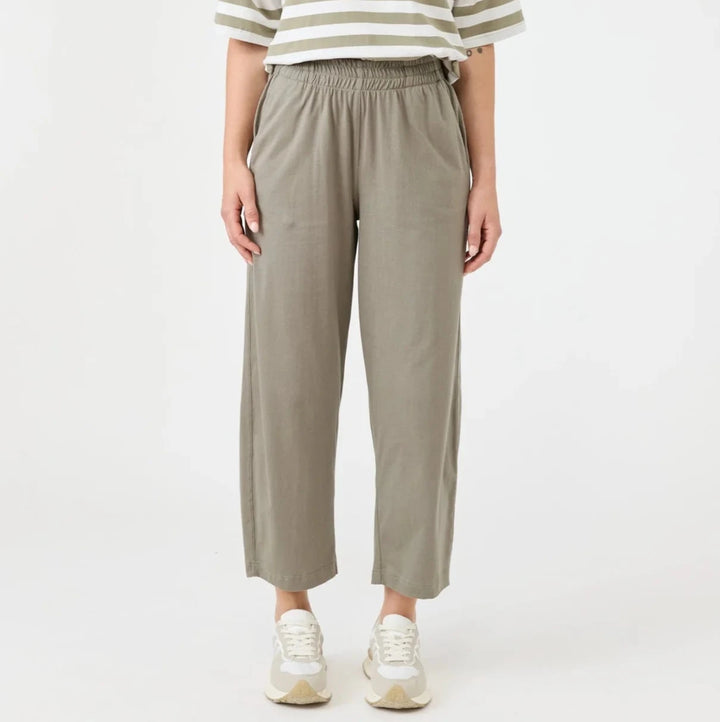 Woman wearing a striped shirt and beige Eb & Ive pants on a white background