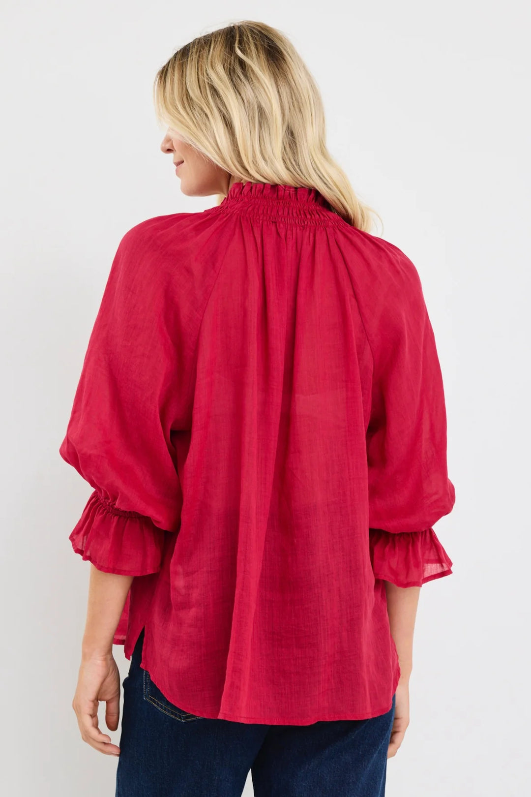 Woman wearing a red among the brave blouse with ruffled sleeves on a white background