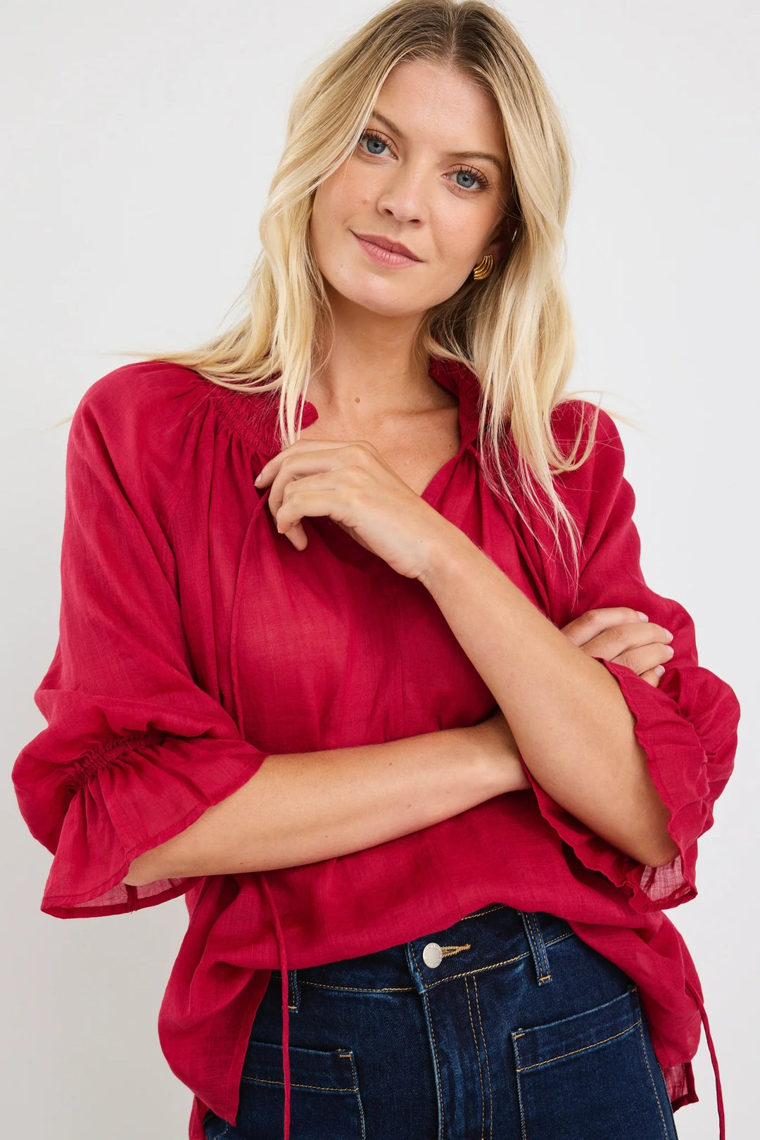 Woman wearing a red among the brave blouse with ruffled sleeves on a white background