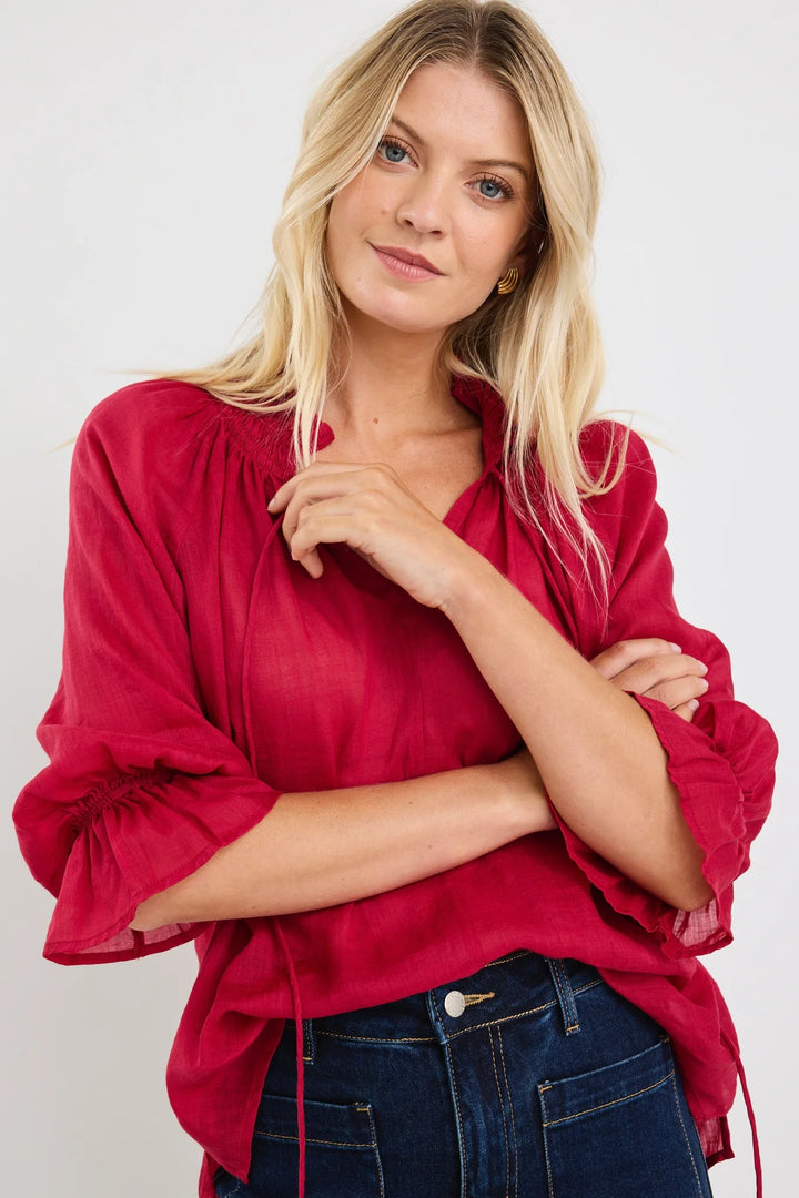 Woman wearing a red among the brave blouse with ruffled sleeves on a white background